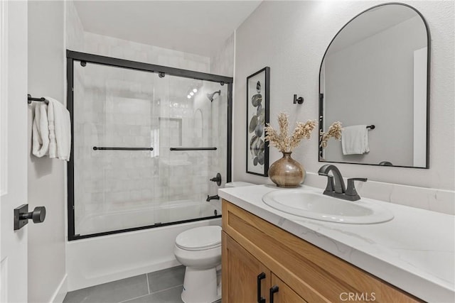 full bathroom with toilet, vanity, shower / bath combination with glass door, and tile patterned flooring