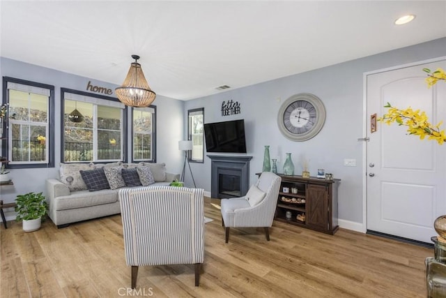 living room with a chandelier and light hardwood / wood-style floors