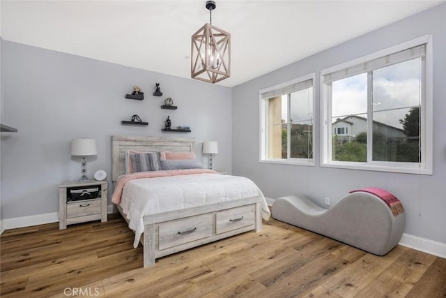 bedroom featuring wood-type flooring and an inviting chandelier