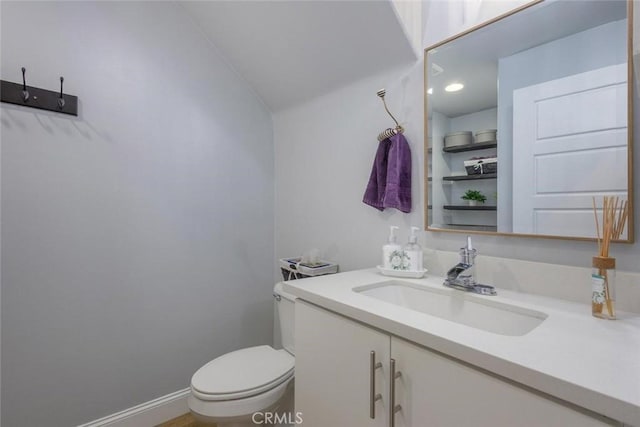 bathroom with vanity, vaulted ceiling, and toilet