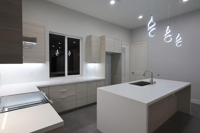 kitchen featuring light brown cabinetry, sink, and an island with sink