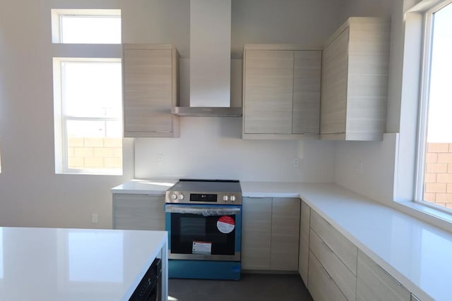 kitchen with stainless steel electric range oven and wall chimney range hood