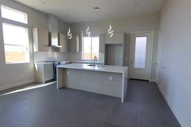 kitchen with pendant lighting, an island with sink, sink, and electric range