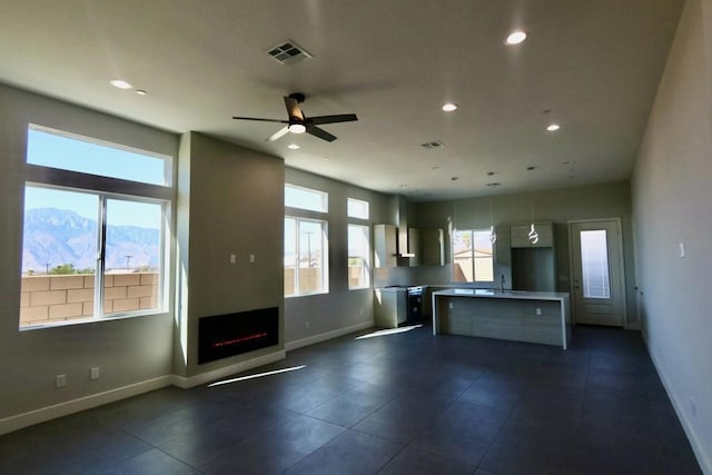 kitchen with a mountain view, sink, ceiling fan, and a kitchen island