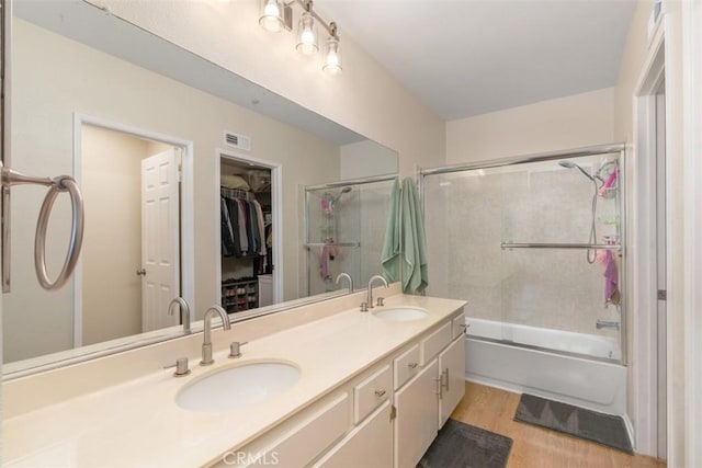 bathroom featuring vanity, hardwood / wood-style floors, and shower / bath combination with glass door