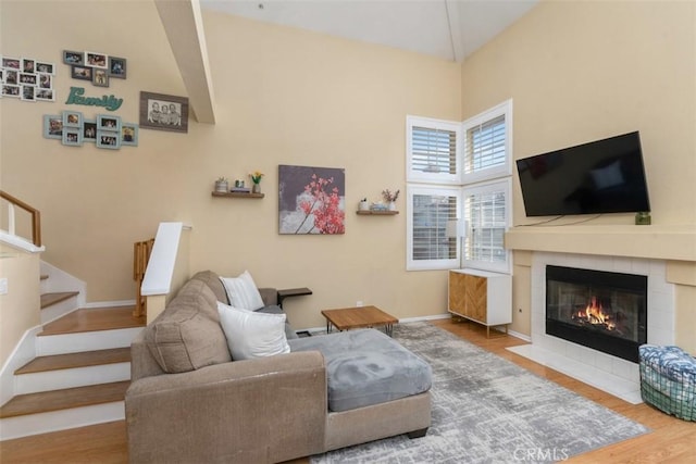 living room with hardwood / wood-style flooring and a tile fireplace