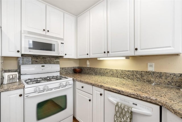 kitchen featuring white appliances, light stone countertops, and white cabinets