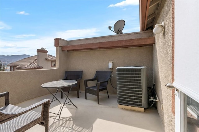 view of patio with cooling unit, a mountain view, and a balcony