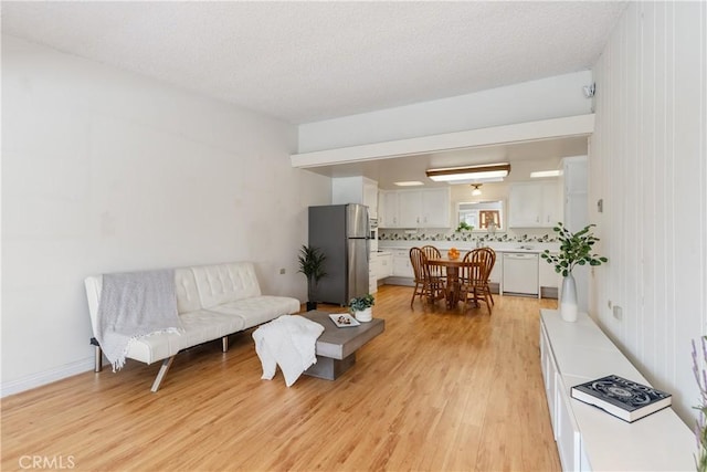 living room with a textured ceiling and light hardwood / wood-style flooring