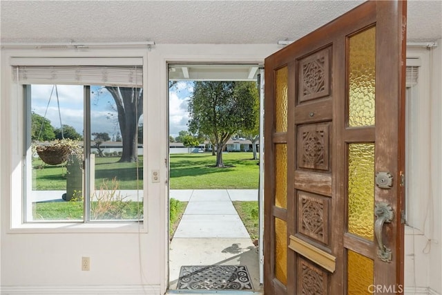 doorway to outside featuring a textured ceiling