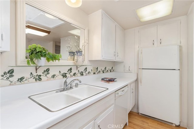 kitchen with white cabinetry, sink, white appliances, and light wood-type flooring