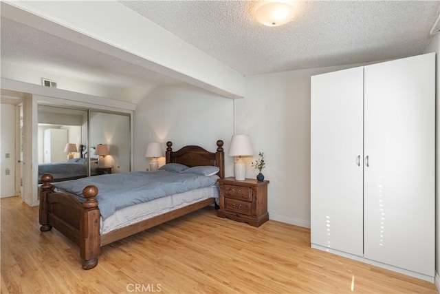 bedroom featuring light hardwood / wood-style flooring and a textured ceiling