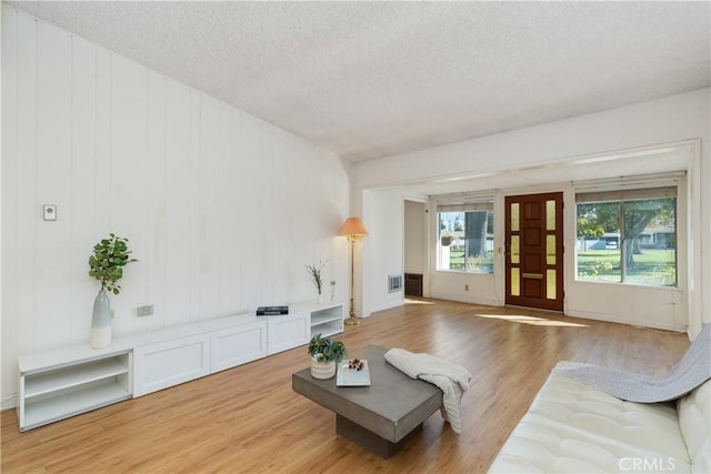 living room with wood-type flooring and a textured ceiling