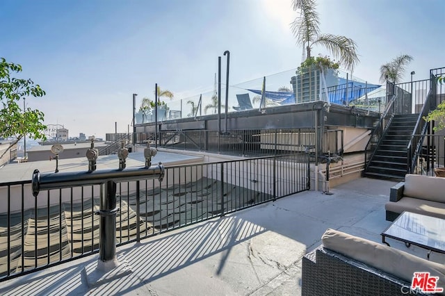 view of patio / terrace featuring fence and stairway