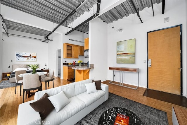 living room with hardwood / wood-style flooring and a towering ceiling