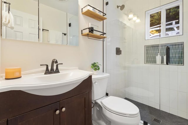 bathroom with vanity, a shower with shower door, and toilet