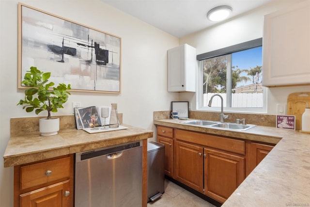 kitchen featuring sink, stainless steel dishwasher, and light tile patterned floors