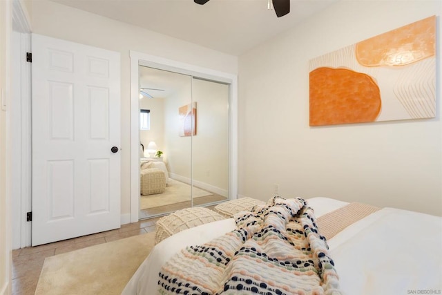 bedroom with light tile patterned floors, ceiling fan, and a closet