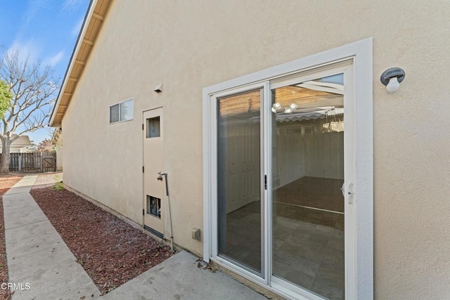 exterior space with stucco siding and fence