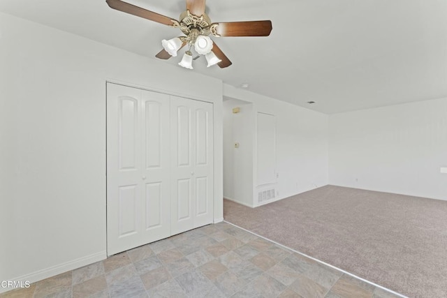 interior space featuring light carpet, a closet, ceiling fan, and visible vents
