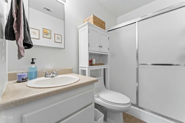 bathroom featuring visible vents, toilet, a shower stall, and vanity