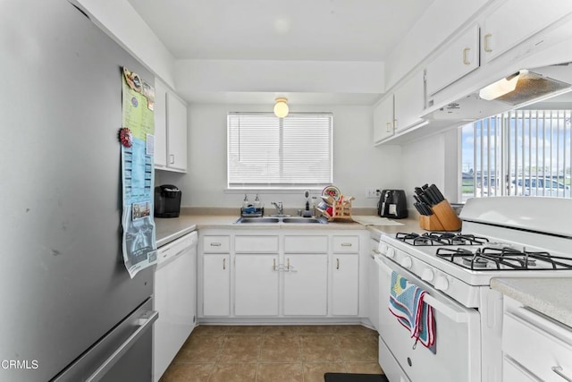 kitchen with light tile patterned floors, a sink, light countertops, white appliances, and white cabinetry