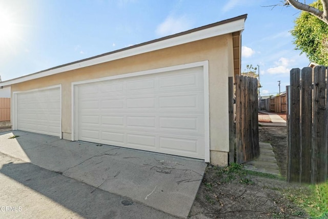detached garage featuring fence