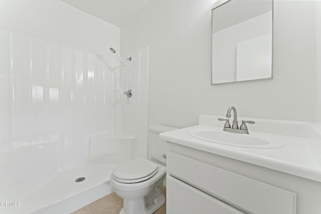 bathroom featuring a shower, tile patterned floors, vanity, and toilet