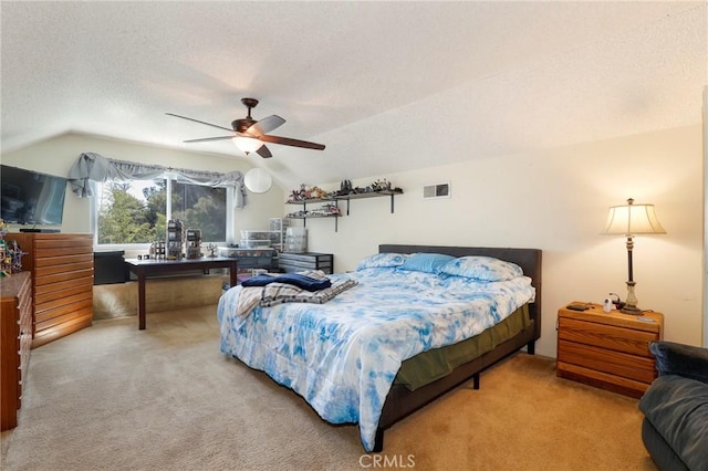 bedroom featuring ceiling fan, vaulted ceiling, a textured ceiling, and carpet flooring