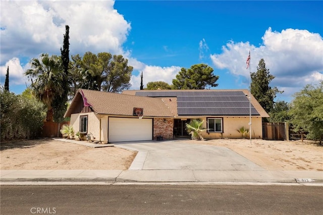 single story home featuring a garage and solar panels