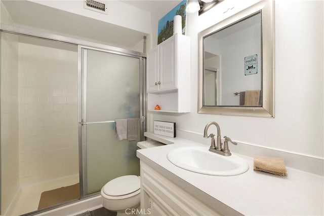 bathroom featuring vanity, an enclosed shower, and toilet