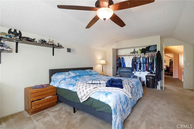 bedroom with lofted ceiling, light colored carpet, a closet, and a textured ceiling