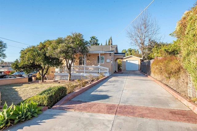 view of front of property featuring a porch, a garage, and an outdoor structure