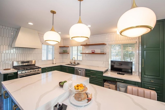 kitchen featuring pendant lighting, sink, premium range hood, appliances with stainless steel finishes, and green cabinetry