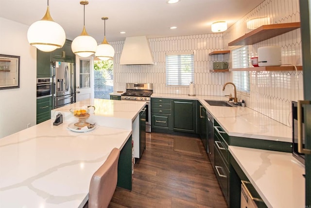 kitchen with sink, appliances with stainless steel finishes, premium range hood, light stone counters, and decorative light fixtures