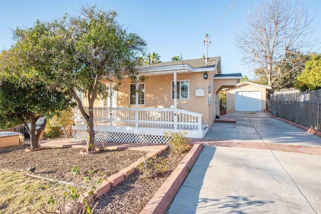 single story home with a garage, an outdoor structure, and a porch