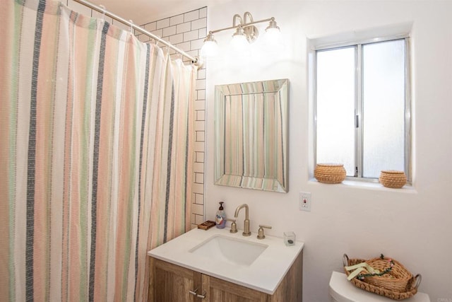 bathroom with walk in shower, vanity, and toilet