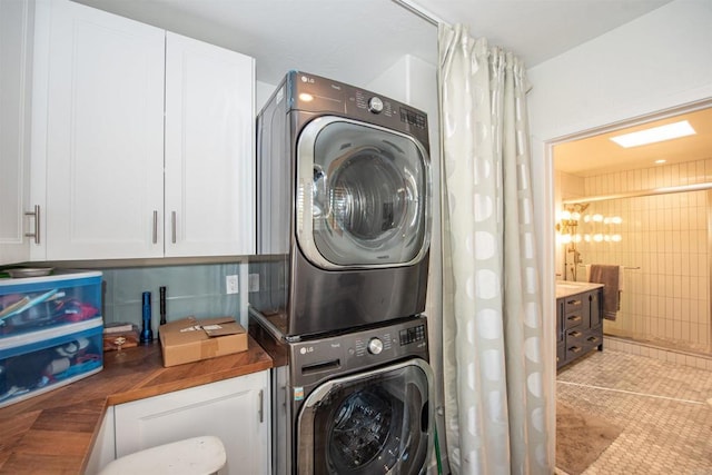 laundry area with stacked washer and dryer and light tile patterned floors