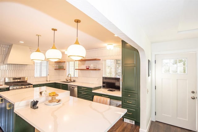 kitchen featuring a breakfast bar area, stainless steel appliances, a center island, decorative light fixtures, and custom exhaust hood