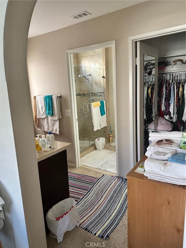 bathroom with vanity and a shower with door