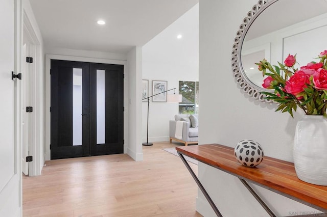 foyer with french doors and light hardwood / wood-style flooring