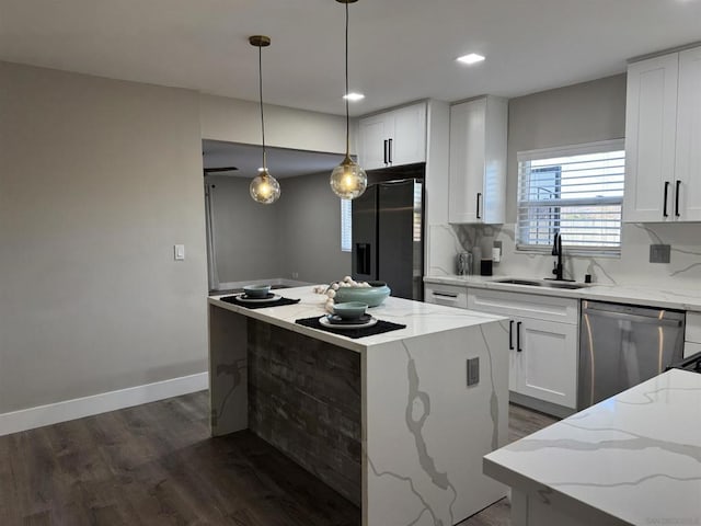 kitchen with dishwasher, sink, white cabinets, refrigerator with ice dispenser, and a center island