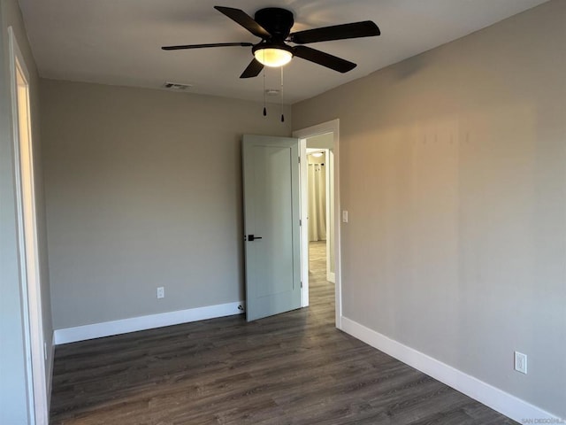 empty room with dark hardwood / wood-style floors and ceiling fan