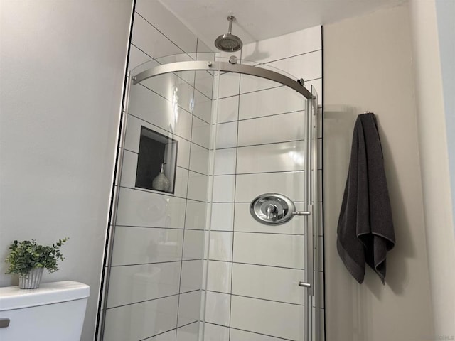 bathroom with an enclosed shower and toilet