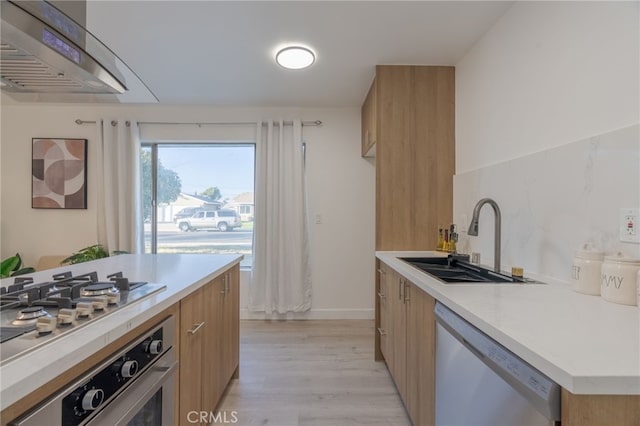 kitchen featuring a sink, light countertops, appliances with stainless steel finishes, light wood finished floors, and modern cabinets