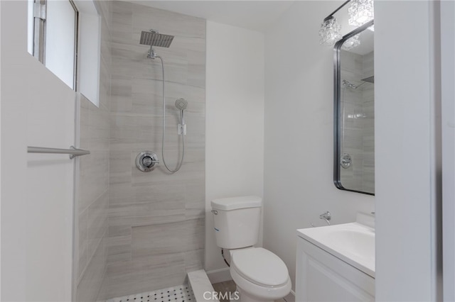 full bathroom featuring toilet, tiled shower, and vanity