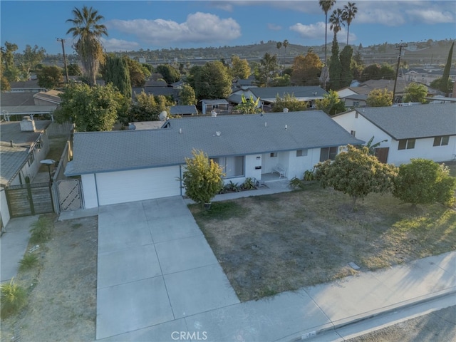 view of front of property featuring a garage, a residential view, driveway, and fence