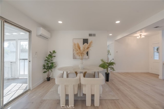 dining area with light wood-style flooring, a wall unit AC, visible vents, and recessed lighting