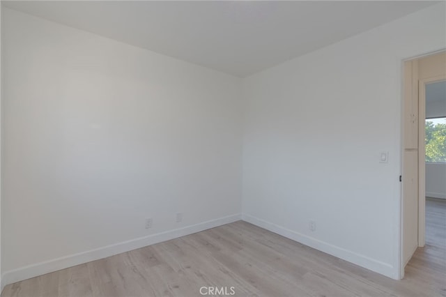 unfurnished room featuring light wood finished floors and baseboards