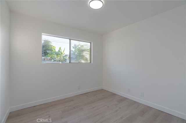 unfurnished room featuring light wood finished floors and baseboards